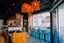 Intérieur d'un restaurant Basilic & Co avec décoration chaleureuse, éclairage suspendu, et vue sur la cuisine