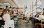 Salle de café restaurant animée avec clients attablés et sol béton